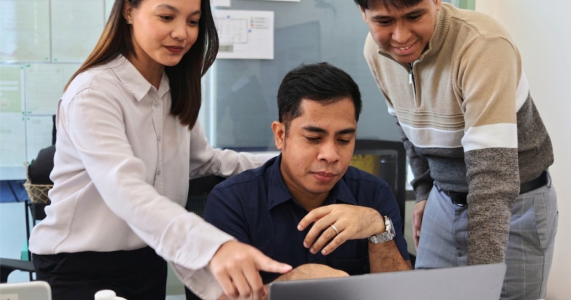 Colleagues reviewing work on a laptop